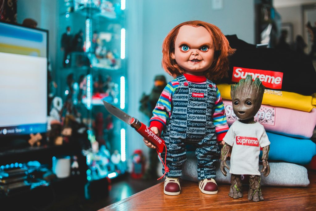 Quirky display featuring Chucky and Groot dolls in iconic Supreme streetwear style.